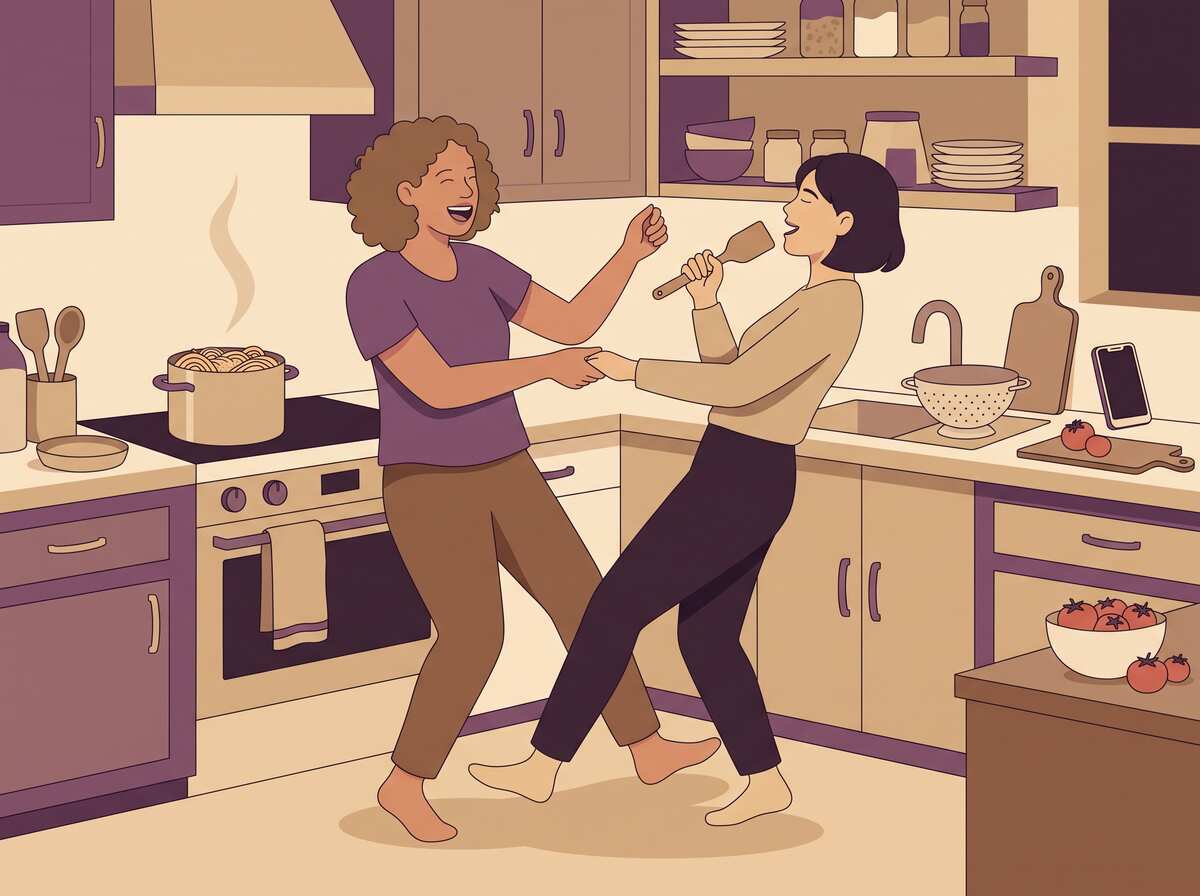 Two women dancing goofily in the kitchen while pasta cooks on the stove.